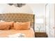 Comfortable bedroom featuring a tufted headboard, plush pillows, and soft lighting at 7219 Oakmoss Loop, Davenport, FL 33837