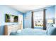 Bedroom featuring blue walls, a television, dresser, and an outside view from the window at 7219 Oakmoss Loop, Davenport, FL 33837