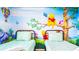 This bedroom features two twin beds and lovely Winnie the Pooh themed decor at 7219 Oakmoss Loop, Davenport, FL 33837