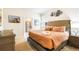 Inviting bedroom with a tufted headboard, soft lighting, and a view into the ensuite bathroom at 7219 Oakmoss Loop, Davenport, FL 33837