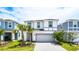 Charming two-story home with a two car garage, palm trees, and a well manicured lawn at 7219 Oakmoss Loop, Davenport, FL 33837
