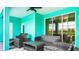 A covered outdoor patio with comfortable seating and view of the screened pool at 7219 Oakmoss Loop, Davenport, FL 33837