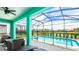 Screened-in pool area with a hot tub and lake view, complete with outdoor seating at 7219 Oakmoss Loop, Davenport, FL 33837