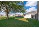Expansive backyard featuring a large shade tree and sliding glass doors leading indoors at 738 Paris Dr, Kissimmee, FL 34759