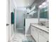 Beautiful bathroom featuring double sinks, a large mirror, and a glass shower enclosure at 7709 Comrow St, Kissimmee, FL 34747