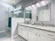 Modern bathroom with a double sink vanity, large mirror, and walk-in glass shower at 7709 Comrow St, Kissimmee, FL 34747