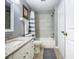 Well-lit bathroom featuring modern fixtures, a tub and shower, and a gray and white color scheme at 7709 Comrow St, Kissimmee, FL 34747