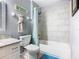 Modern bathroom featuring a tub with marble tile surround and updated fixtures at 7709 Comrow St, Kissimmee, FL 34747