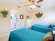 Bright bedroom with two twin beds, a ceiling fan, and a connecting bathroom at 7709 Comrow St, Kissimmee, FL 34747