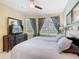 Bright bedroom offers a large dresser, TV, ceiling fan, and lots of natural light at 7709 Comrow St, Kissimmee, FL 34747
