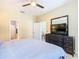 This bedroom has a ceiling fan, ensuite bathroom, walk-in closet, and TV at 7709 Comrow St, Kissimmee, FL 34747