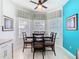 Bright dining area with a ceiling fan, three windows, and dark wood furniture at 7709 Comrow St, Kissimmee, FL 34747