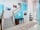 Bright foyer featuring a staircase, art, high ceilings, and sleek flooring at 7709 Comrow St, Kissimmee, FL 34747