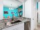 Kitchen sink featuring granite countertops, stainless steel appliances, and view into dining area at 7709 Comrow St, Kissimmee, FL 34747