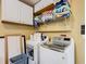 Bright laundry room featuring modern appliances, storage cabinets, and a folding area at 7709 Comrow St, Kissimmee, FL 34747