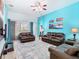 Spacious living room with leather furniture, a ceiling fan, and art pieces at 7709 Comrow St, Kissimmee, FL 34747