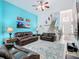 Bright living room with blue accent wall and art, with sofas, rug and staircase visible at 7709 Comrow St, Kissimmee, FL 34747