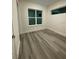 Bright bedroom featuring wood-look floors and ample natural light from two windows at 871 City Walk Ln # B-1, Oviedo, FL 32765