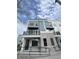 Modern three-story townhome with gray stone and gray siding, with a balcony and prominent street-facing address numbers at 871 City Walk Ln # B-1, Oviedo, FL 32765