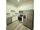 Contemporary kitchen featuring stainless steel appliances, white cabinets, and sleek backsplash at 871 City Walk Ln # B-1, Oviedo, FL 32765