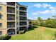 Lovely condo building featuring screened balconies, lush green lawns, and a peaceful, serene wooded backdrop at 8762 Worldquest Blvd # 6506, Orlando, FL 32821