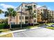 A charming condominium building with a beige and peach facade, tropical palm trees, and ample parking at 8762 Worldquest Blvd # 6506, Orlando, FL 32821
