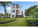 Exterior building view with beautiful green landscaping, tall trees, and well-manicured shrubs at 100 S Interlachen Ave # 304, Winter Park, FL 32789