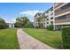 Green community grounds featuring mature trees, walking path and view of residential building at 100 S Interlachen Ave # 304, Winter Park, FL 32789