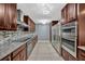 Modern kitchen featuring stainless steel appliances, granite countertops, mosaic backsplash, and updated dark wood cabinetry at 1005 Leeds Ct, Winter Park, FL 32792