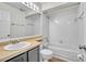 Bright bathroom featuring a tub with white tile surround, white toilet, and a vanity sink with a cream countertop at 1008 Birkdale Trl, Winter Springs, FL 32708
