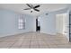 Bright main bedroom with tile floors, ceiling fan, window, and access to the main bathroom at 1008 Birkdale Trl, Winter Springs, FL 32708