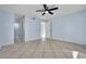 Light blue bedroom featuring tile floors, ceiling fan, window, and multiple access doors at 1008 Birkdale Trl, Winter Springs, FL 32708