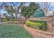 Landscaped entrance to Greenbriar community with brick wall and greenery at 1008 Birkdale Trl, Winter Springs, FL 32708