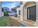 Home exterior featuring a front entrance, with a dark door, textured walls, and established landscaping at 1008 Birkdale Trl, Winter Springs, FL 32708