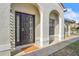 Inviting front door entrance featuring a sleek black door, textured walls, and an elegant archway at 1008 Birkdale Trl, Winter Springs, FL 32708