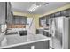 Modern kitchen featuring quartz countertops, stainless steel appliances, and access to other rooms at 1008 Birkdale Trl, Winter Springs, FL 32708