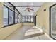 A sunroom has tile flooring, many windows and a ceiling fan for comfortable living and lighting at 1008 Birkdale Trl, Winter Springs, FL 32708