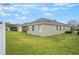 Exterior view of the backyard featuring a well-maintained lawn and a stucco home at 105 Adoncia Way, Sanford, FL 32771