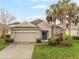 Charming single-story home with a well-manicured lawn and lush landscaping, including beautiful palm trees at 105 Adoncia Way, Sanford, FL 32771