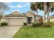 Attractive home featuring a two-car garage, neutral exterior, and green lawn at 105 Adoncia Way, Sanford, FL 32771
