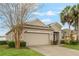 Inviting home with manicured lawn, a two-car garage and stone accents at 105 Adoncia Way, Sanford, FL 32771