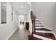 Elegant foyer with a staircase, neutral walls, tile flooring, and natural light shining through adjacent rooms at 1064 Castle Pines Ct, Reunion, FL 34747