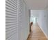 Hallway with wood floors and multiple storage closets with louvered doors at 1100 S Orlando Ave # 301, Maitland, FL 32751