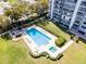 Aerial view of condo's pristine pool and spa with surrounding lounge area and lush landscaping at 1100 S Orlando Ave # 301, Maitland, FL 32751
