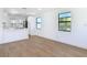 Bright living room with wood floors, modern white kitchen, and two windows at 112 Azalea Dr, Daytona Beach, FL 32117