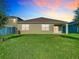 Spacious backyard with lush green grass, offering a private outdoor space with sliding glass door access to the home at 1133 August Sky Dr, Deltona, FL 32738