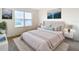 Cozy staged bedroom with a large window, mountain art, and a comfortable bed with matching nightstands at 1133 August Sky Dr, Deltona, FL 32738