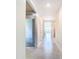 Bright hallway featuring tile flooring and neutral walls, leading to various rooms within the home at 1133 August Sky Dr, Deltona, FL 32738