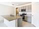 Well-lit kitchen features stainless steel appliances, granite countertops, gray cabinets, and large central island at 1133 August Sky Dr, Deltona, FL 32738