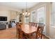 Dining room features wood table and chairs, decorative chandelier, and access to living room and outdoor area at 1180 Killaloe Ter, Chuluota, FL 32766